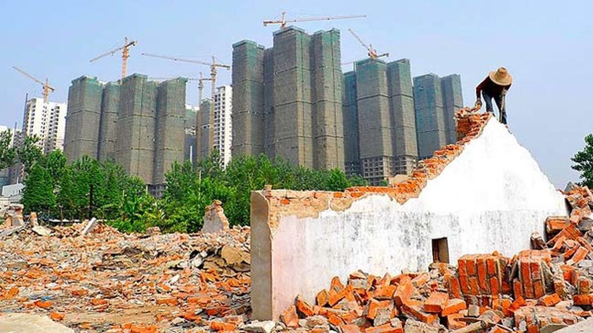 Un camperol recull els totxos d’una casa derruïda amb la intenció de reutilitzar-los.