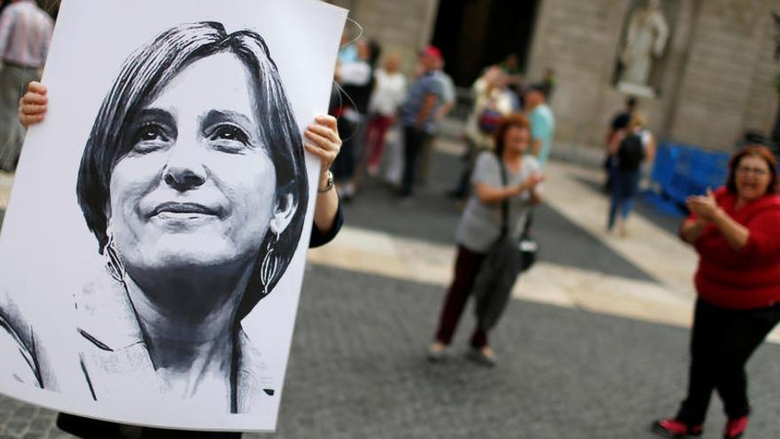 Una mujer sujeta un cartel con la imagen de Carme Forcadell.