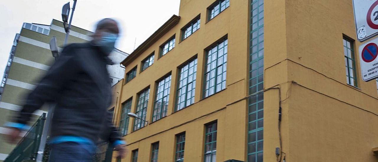 Palacio valdés, uno de los centros sin clases presenciales. Un hombre pasea por el entorno del colegio del Carbayedo.