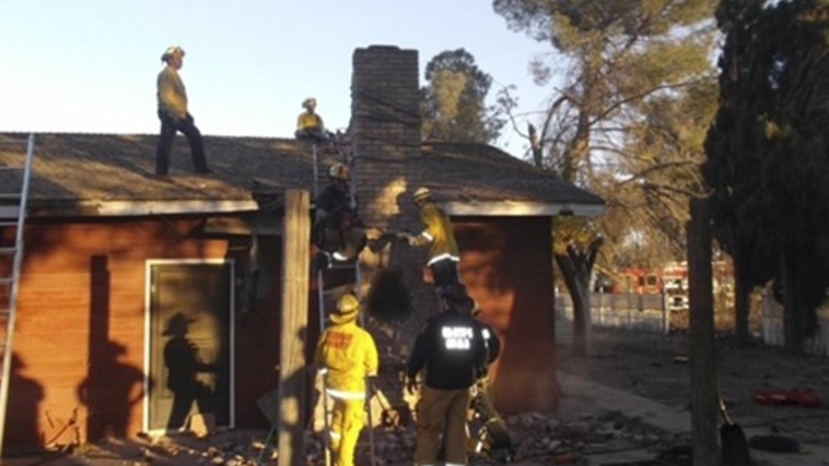 Los bomberos, tras desmontar la chimenea para rescatar el cadáver del presunto ladrón, en Fresno (California).