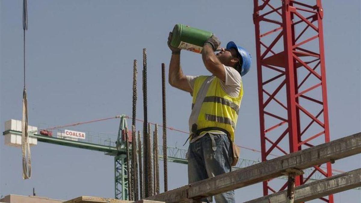 Un trabajador bebe agua en una obra.