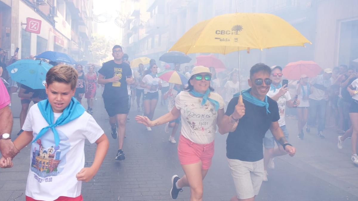 Muchos corredores se protegen con paraguas y gorros para protegerse de los petardos.