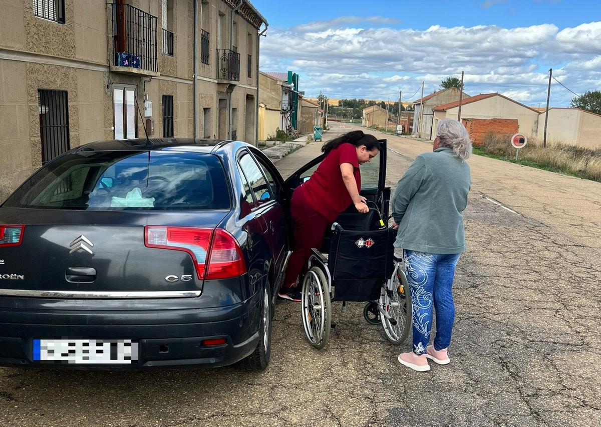 María se apea de su coche a la puerta de su casa, sin aparcamiento para minusvalidos, invadiendo la calzada.