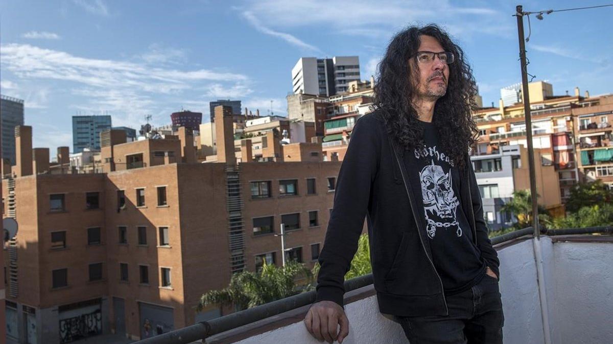 El dibujante Jaime Martín, fiel a Motörhead como demuestra su camiseta, rodeado de edificios del viejo y el nuevo L'Hospitalet, en la casa donde creció, la pasada semana.