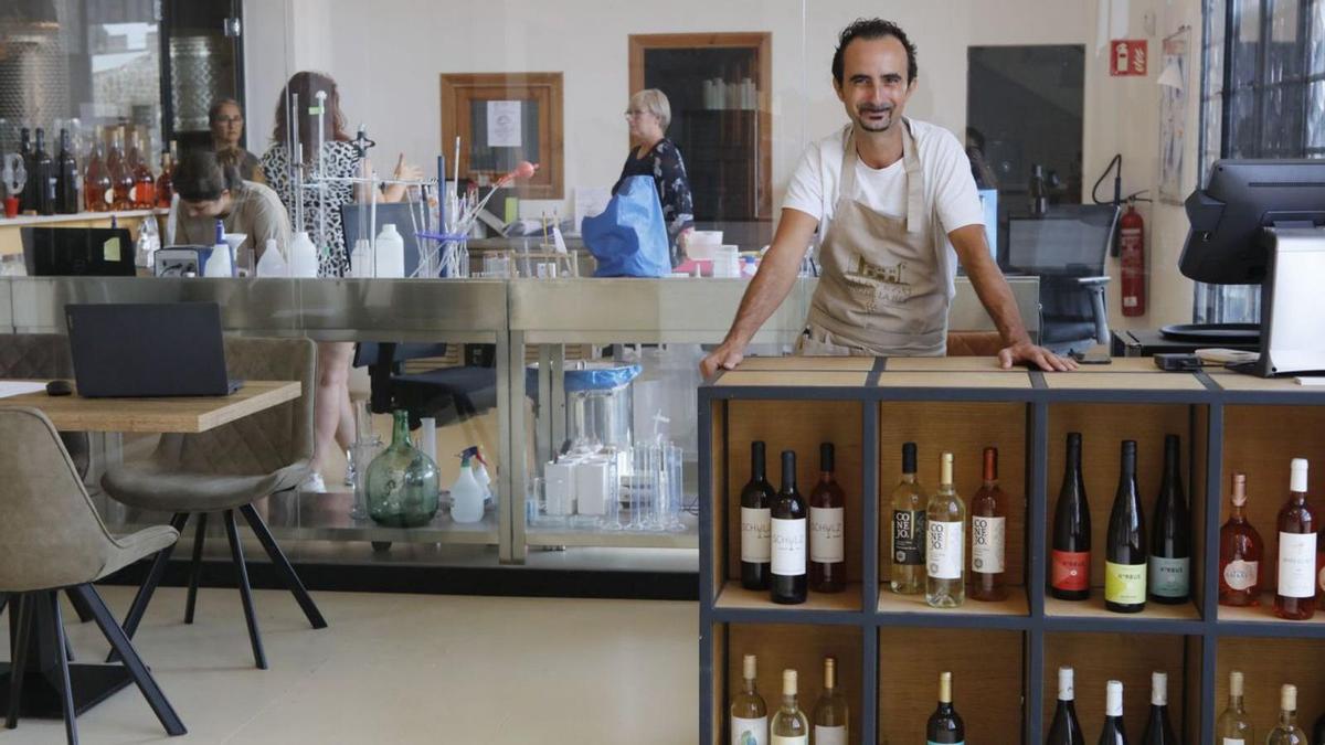 José García empfängt Gäste, hinter ihm im Labor wird unterdessen Wein analysiert. | FOTO: NELE BENDGENS