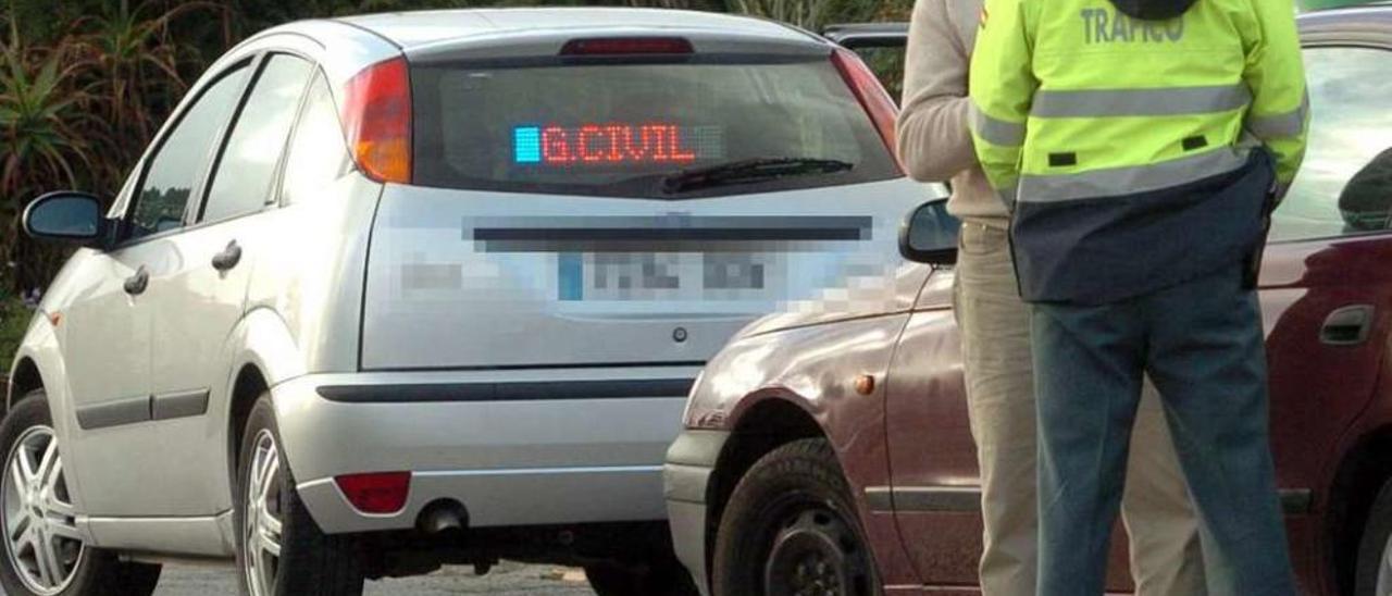 Un agente con un conductor interceptado por un coche camuflado de la Guardia Civil. // R. Grobas