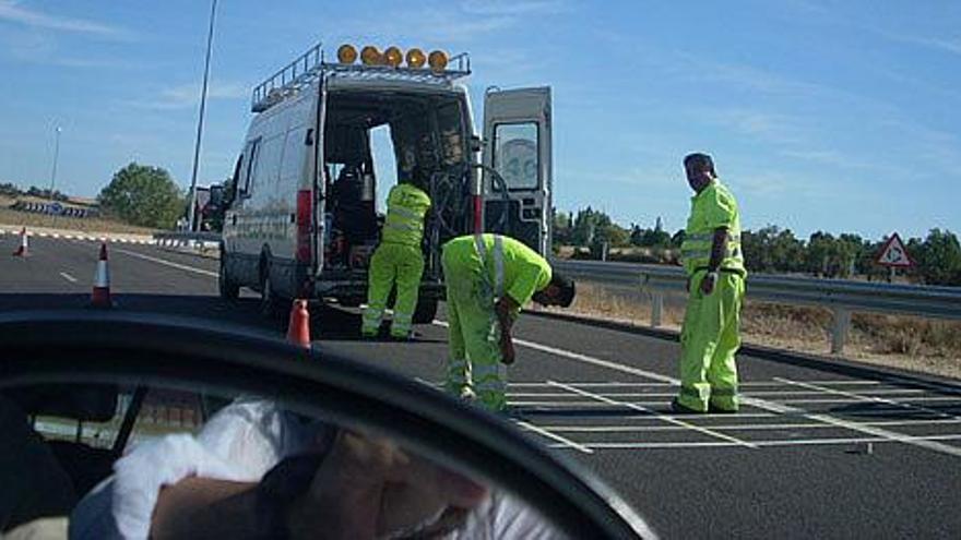 Varios operarios colocan las bandas en una de las rotondas para reforzar la seguridad en el tráfico.