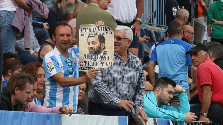 Un aficionado en La Rosaleda, con un cartel que señala al presidente malaguista.