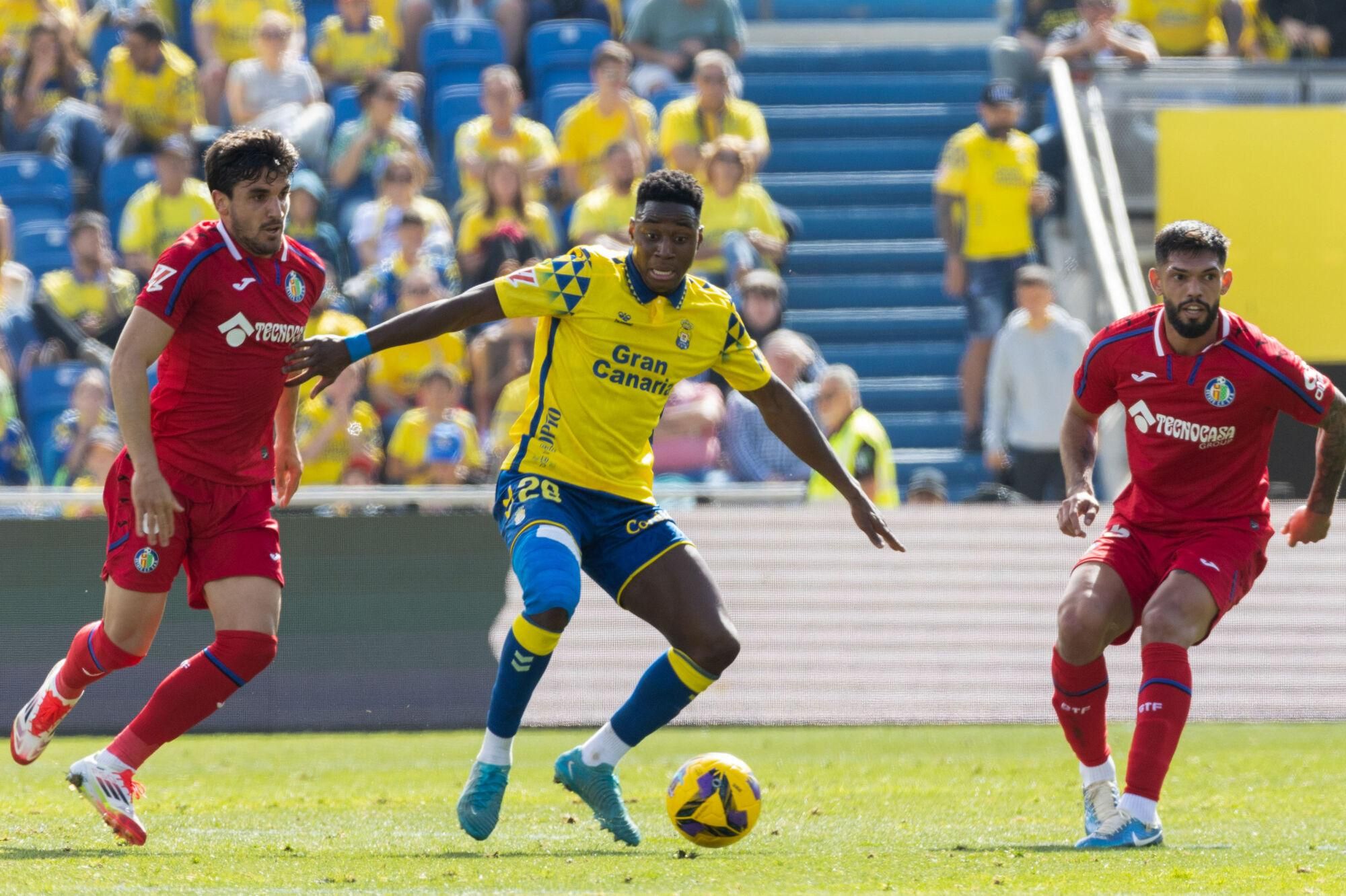 LAS PALMAS DE GRAN CANARIA (ESPAÑA), 12/01/2025.- El centrocampista de la UD Las Palmas, Dario Essugo (c) controla el balón junto a los defensores Alderete (d) y Arambarri (i) del Getafe durante el partido correspondiente a la jornada 19 de LaLiga disputado este domingo en el estadio de Gran Canaria. EFE/ Quique Curbelo