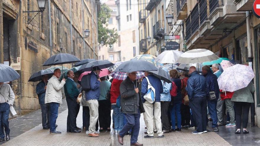 Turistas bajo la lluvia en Oviedo.