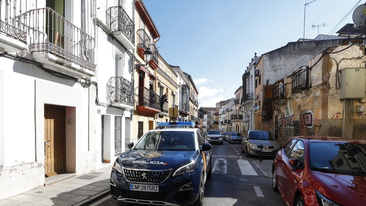 Un coche de Policía Nacional pasa por la casa okupa de Margallo, escenario de los incidentes más recientes en Cáceres.