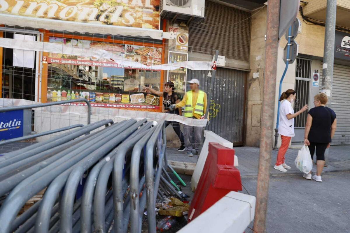 Una mujer conversa con uno de los trabajadores de la obra.