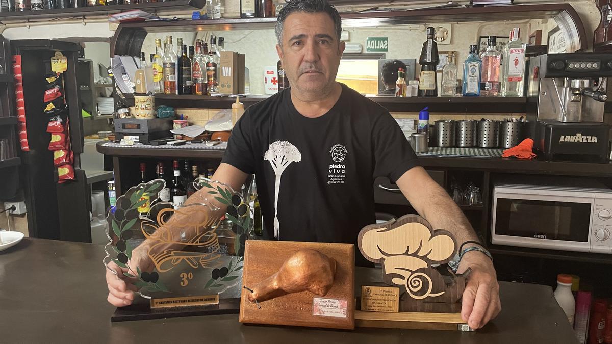 Juan José López, del bar San Antón,  junto a los trofeos que ha conseguido en las jornadas gastronómicas del caracol