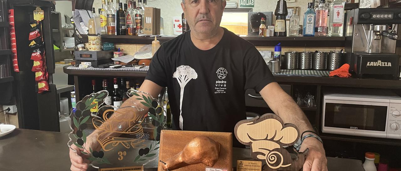 Juan José López, del bar San Antón,  junto a los trofeos que ha conseguido en las jornadas gastronómicas del caracol