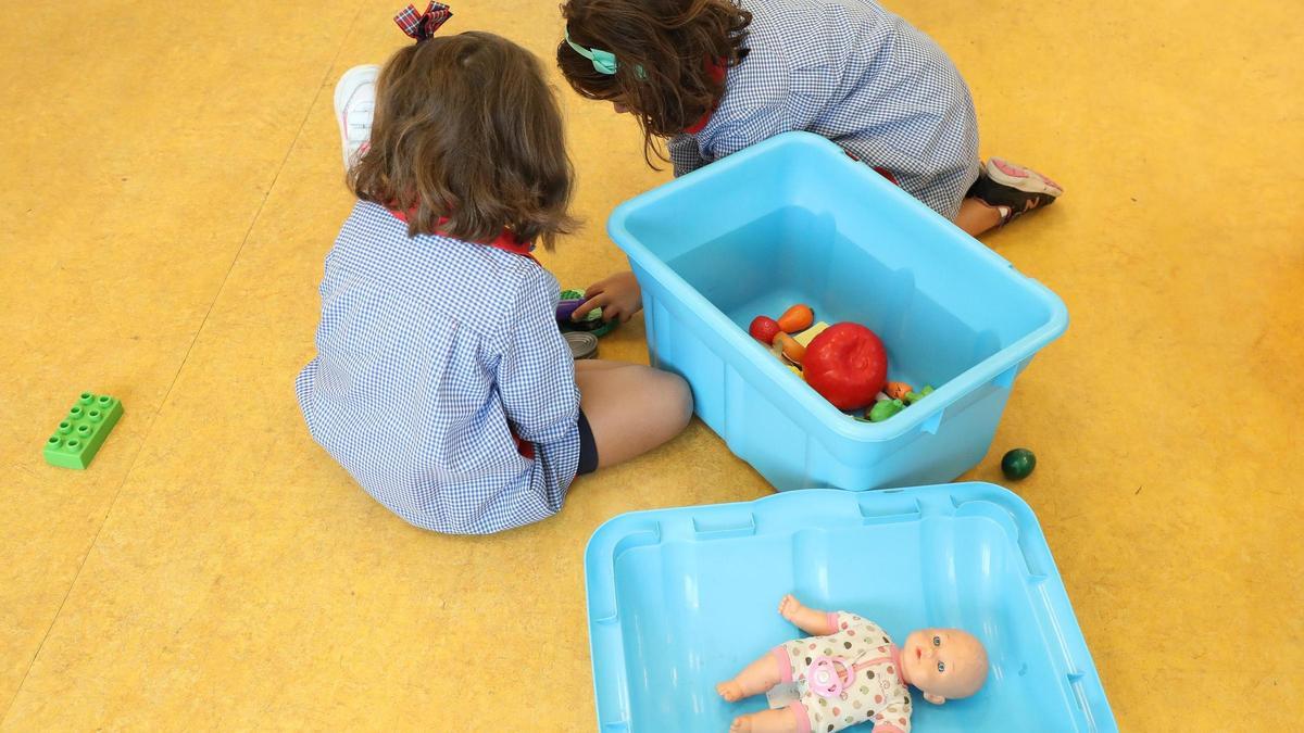 Dos niñas juegan en una escuela con muñecos