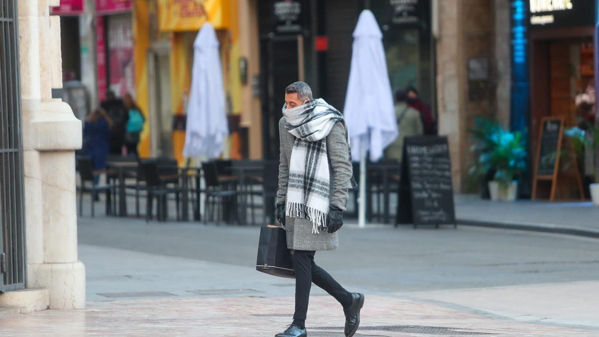 Las temperaturas más bajas se han registrado hoy en municipios del interior de Valencia. En la imagen, un viandante, con valores de apenas 0º C en València ciudad.