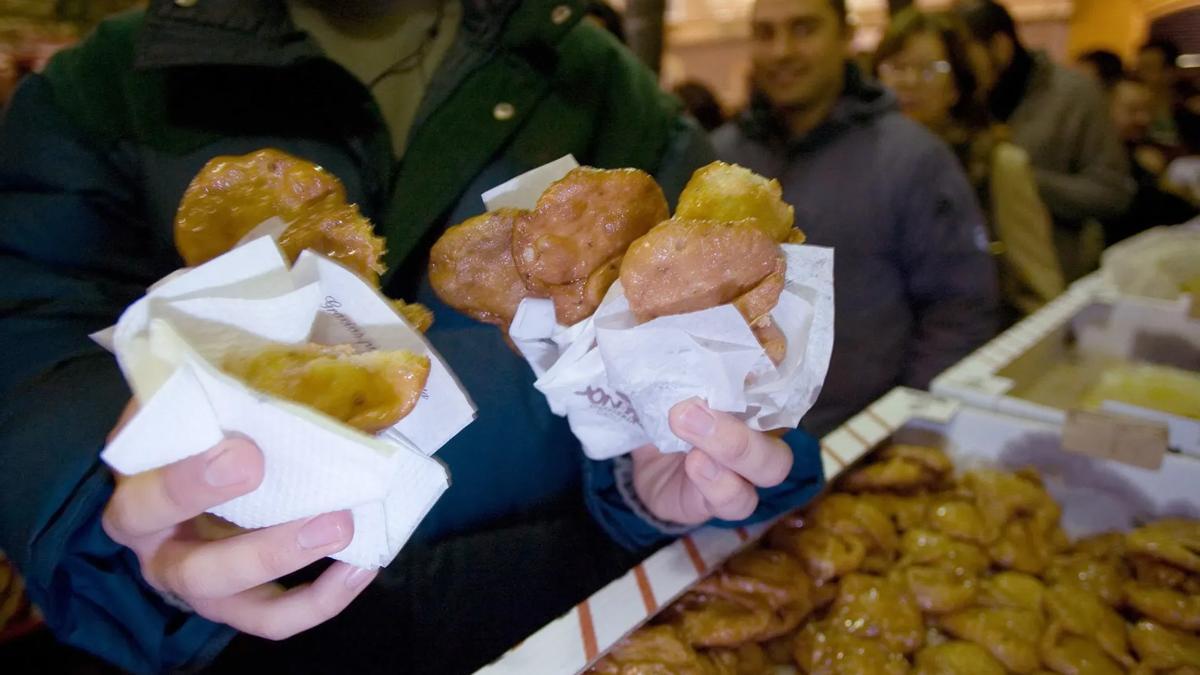 Un hombre muestra varios pestiños de la "Pestiñada", que es la primera de las fiestas gastronómicas que abren la puerta al Carnaval de Cádiz.