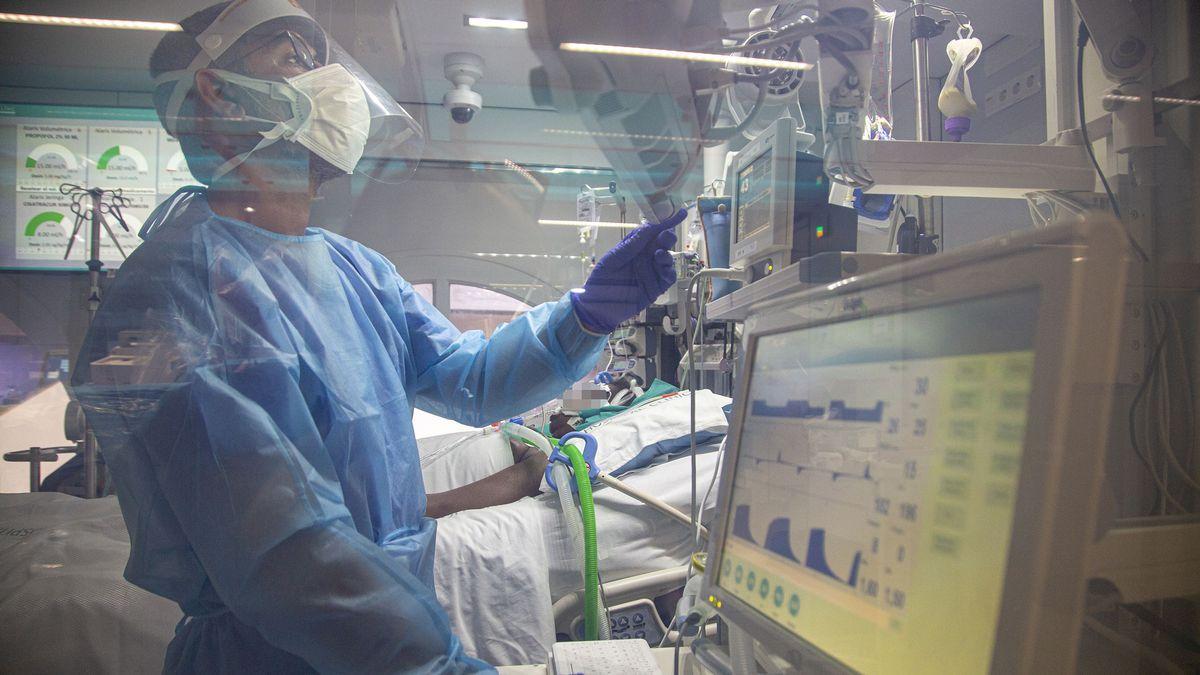 Un sanitario asiste a un enfermo de covid-19, en la UCI del Hospital Clínic de Barcelona.
