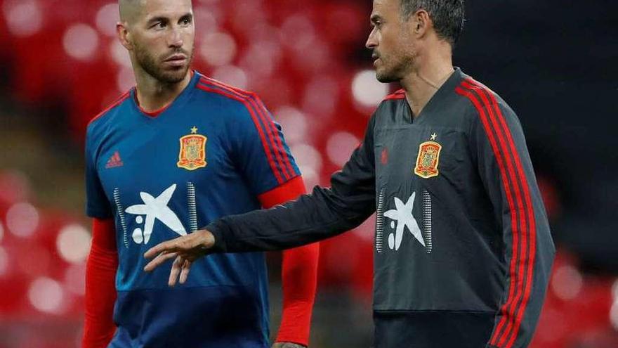 Luis Enrique charla con Sergio Ramos durante el entrenamiento vespertino de ayer en Wembley. // Reuters