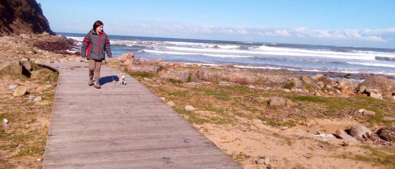 Carmen Tuero, paseando por la playa ayer, entre restos dejados por la marea en el arenal maliayés.