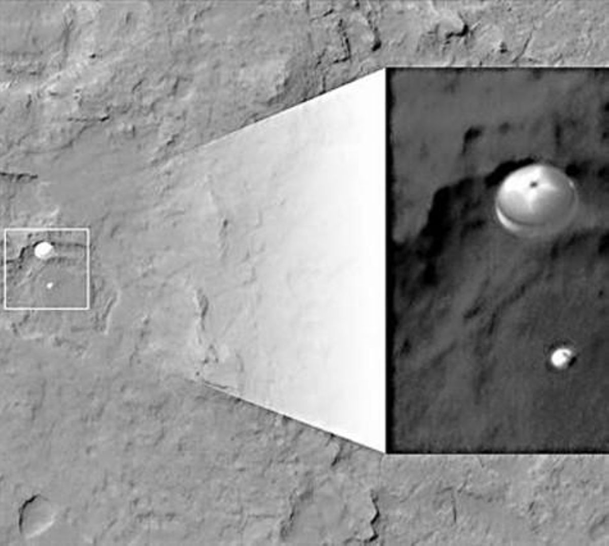 El robot ’Curiosity’, frenat per un paracaigudes en ple aterratge, fotografiat per un satèl·lit de la NASA. El robot ’Curiosity’, frenat per un paracaigudes en ple aterratge, fotografiat per un satèl·lit de la NASA.