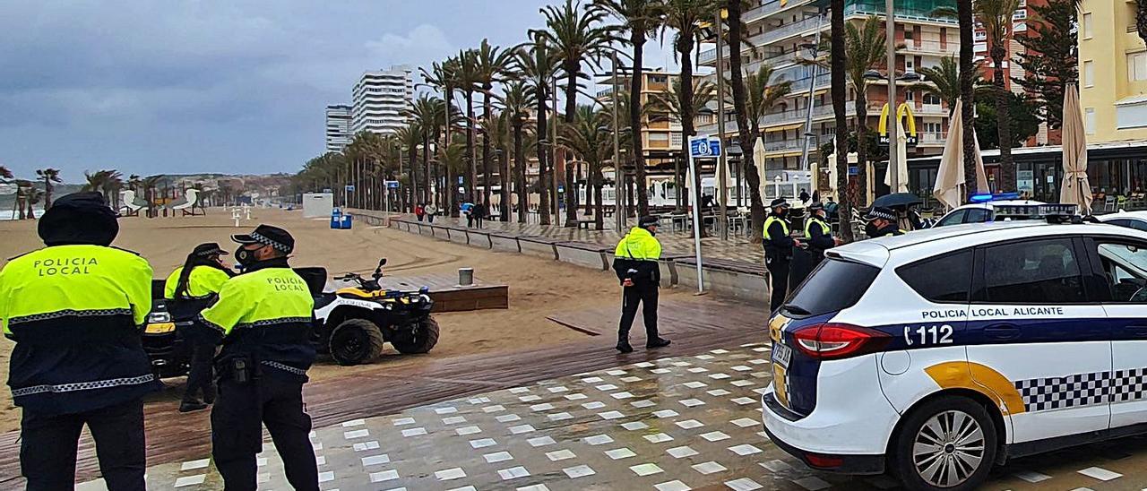 Despliegue policial ayer en la playa de San Juan, donde no se celebraron botellones por el mal tiempo. Abajo a la izquierda, la Policía Local requisa alcohol a tres jóvenes