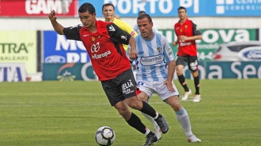 Castro controla el balón perseguido por Apoño.