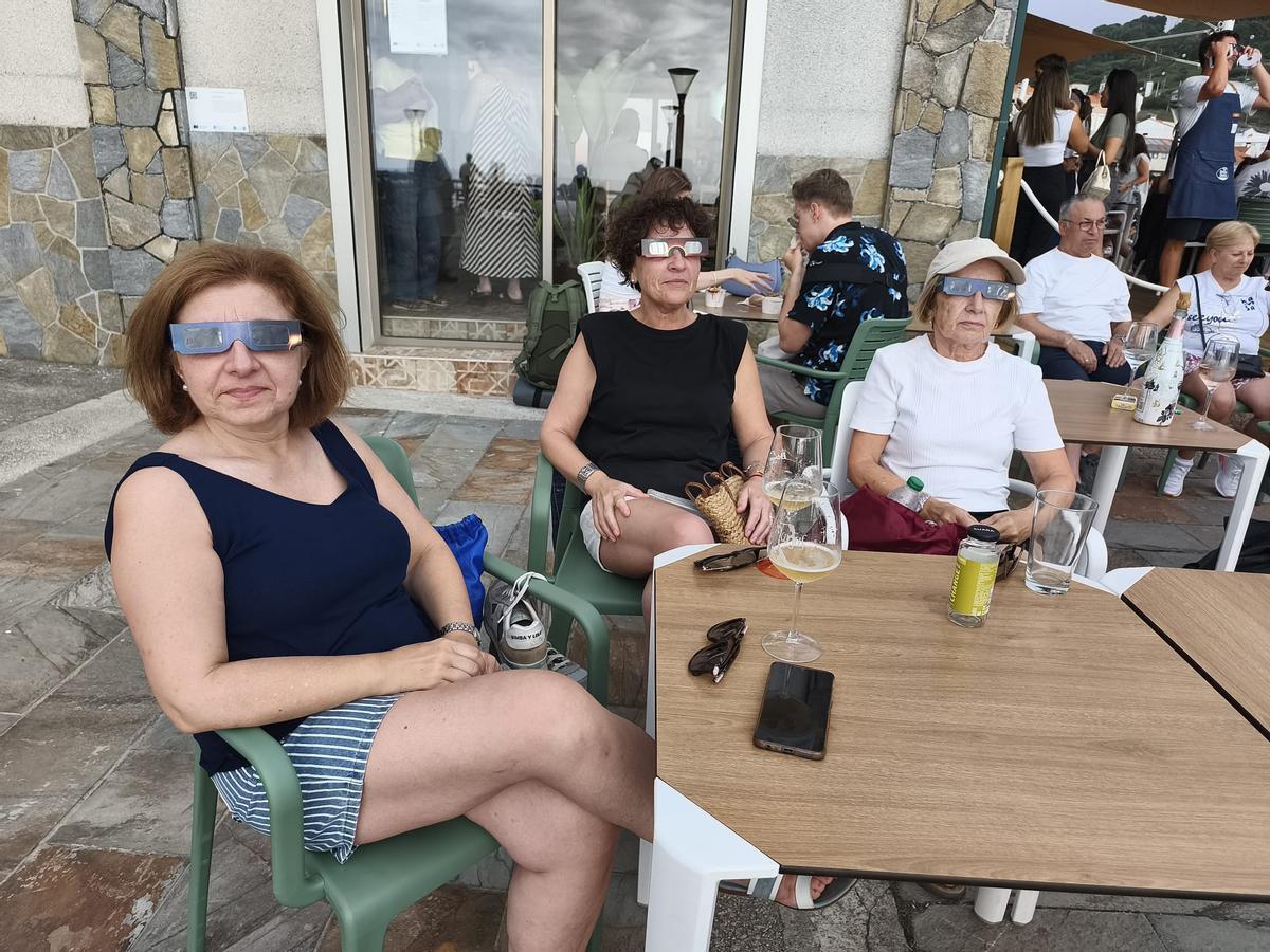 Unas mujeres aguardan por el eclipse en una terraza de Caión.