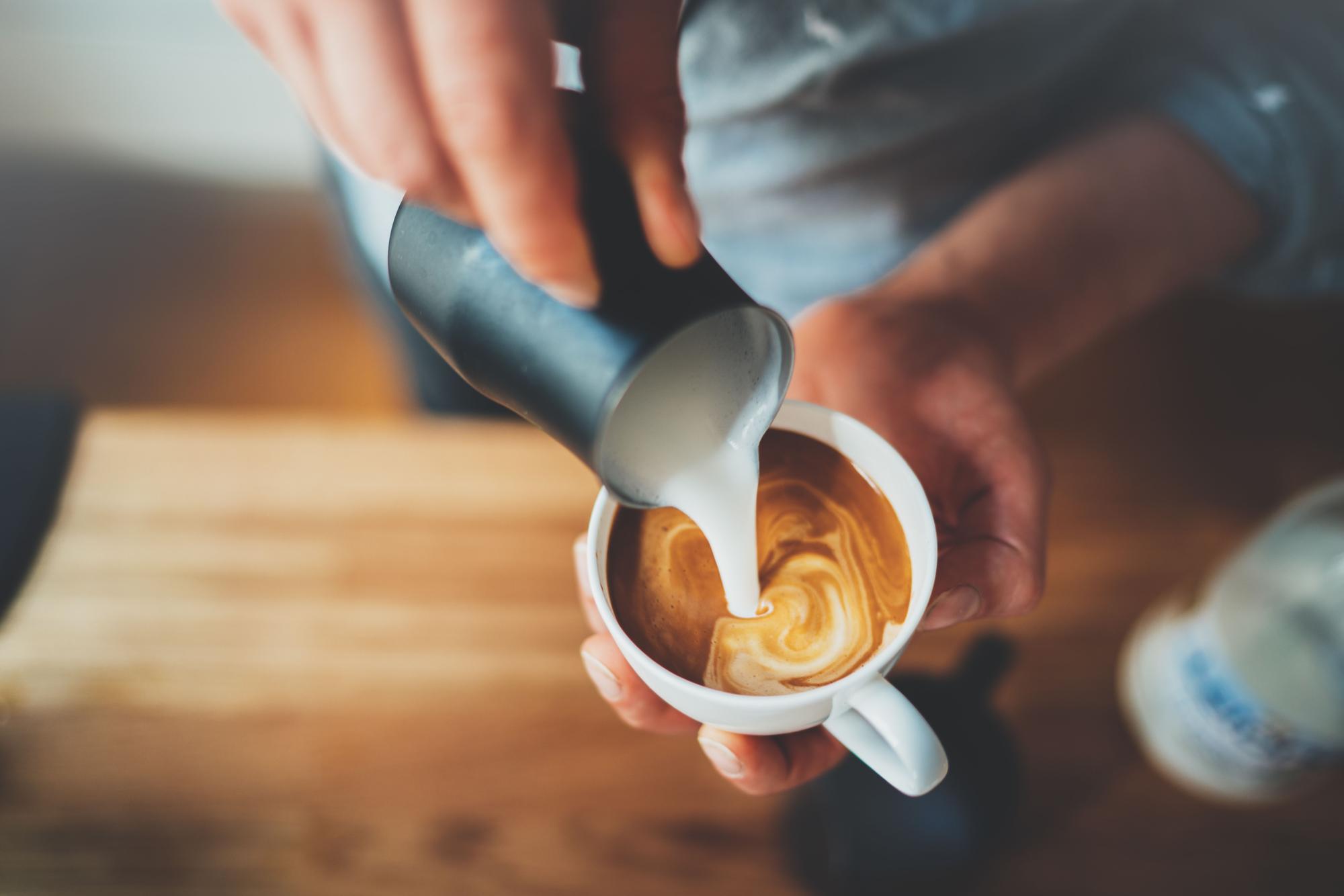 Una mujer prepara un café con leche .