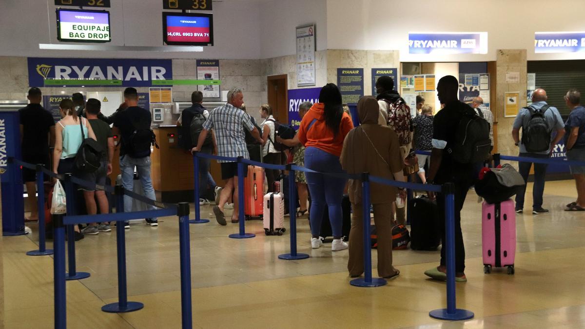 Diversos passatgers fan cua per facturar les maletes en els taulells de Ryanair de l&#039;aeroport de Girona