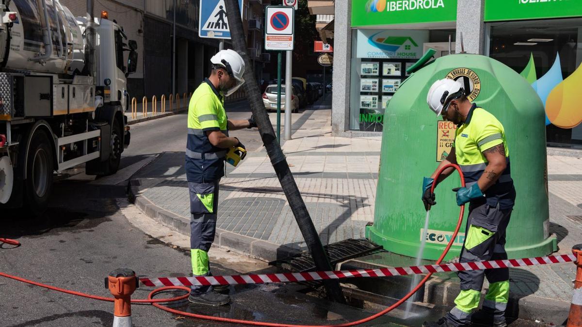 Operarios limpian un imbornal en la calle San Martín de Porres de Cartagena  | LOYOLA PÉREZ DE VILLEGAS