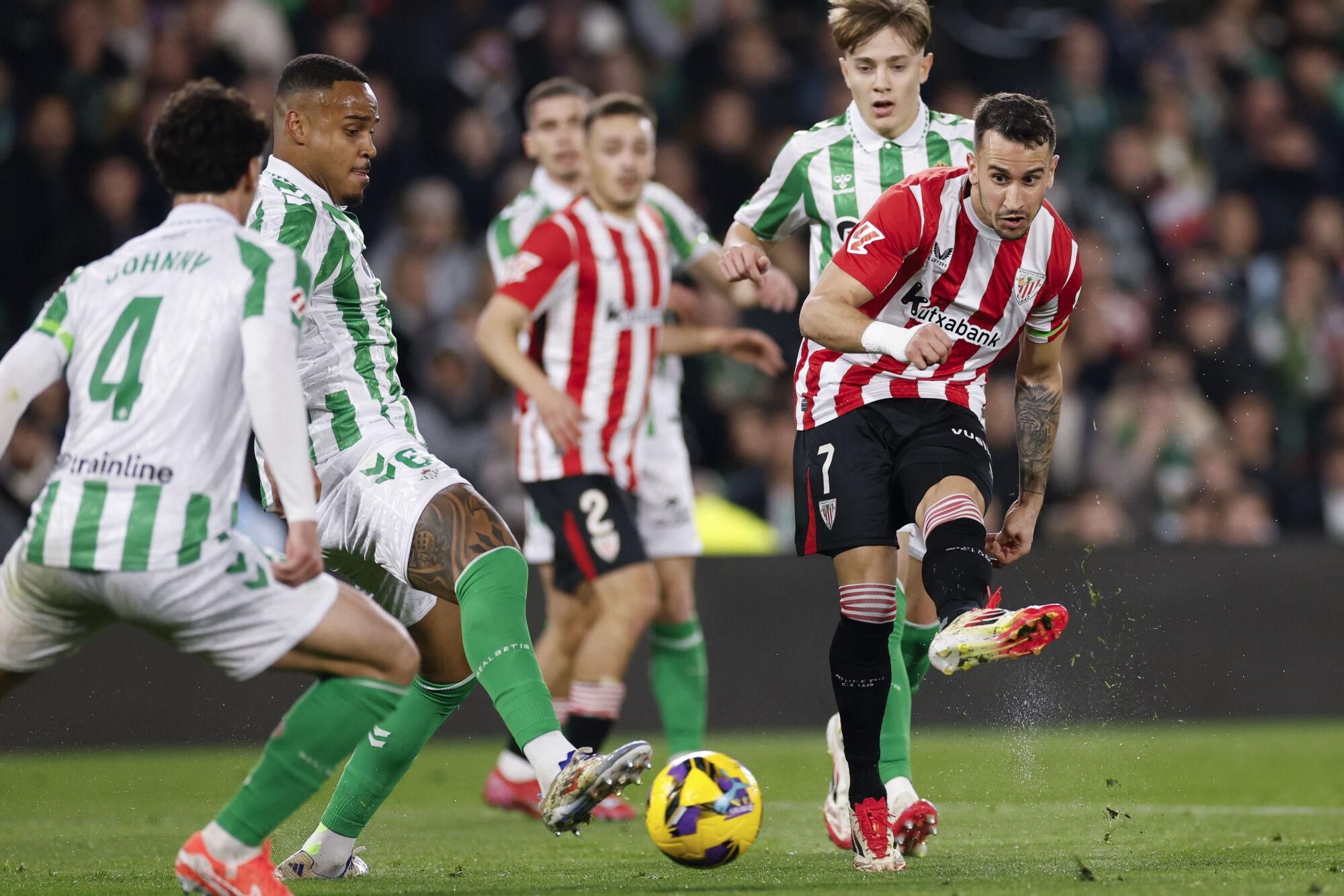 SEVILLA, 02/02/2025.- El delantero del Athletic Club, Álex Belenguer (d), remata ante los defensores del Betis durante el encuentro correspondiente a la jornada 22 de Laliga EA Sports que disputan hoy domingo Betis y Athletic Club en el estadio Benito Villamarín, en Sevilla. EFE / Julio Muñoz.