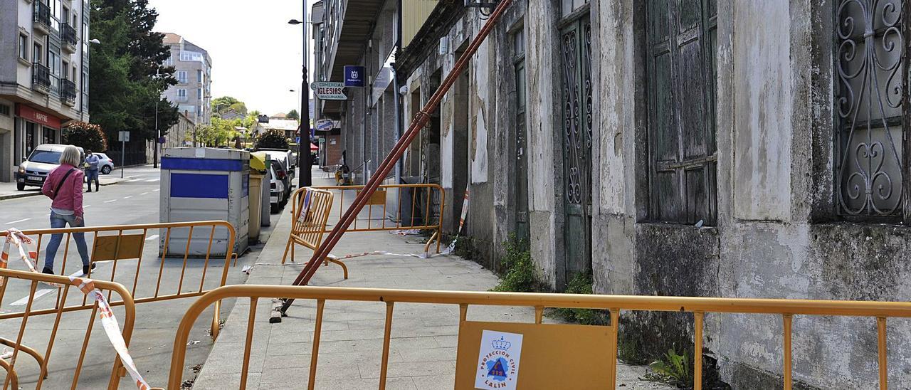 Desplome del tejado en un inmueble de A Cacharela. El desplome de la cubierta de un antiguo inmueble situado en la zona de A Cacharela (Lalín) obligó a los servicios municipales de emergencias a acordonar su perímetro para evitar daños a peatones o vehículos por el desprendimiento de materiales. Protección Civil colocó vallas metálicas delante de la fachada de la casa, ocupando también una parte de la zona reservada al aparcamiento. Algunos vecinos de la zona mostraron su malestar por la demora con la que se llevan los trabajos de apuntalamiento de la edificación, una casa que como otras en Lalín condenadas a convertirse en escombro pese a su encanto histórico. | FDV