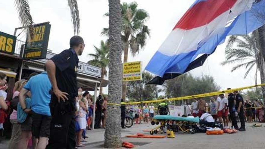 Dotaciones sanitarias atienden a las mujeres heridas mientras el paracaídas sigue colgado de la palmera en la primera línea de s´Arenal.