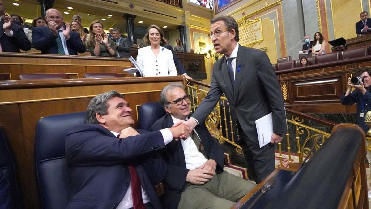 Alberto Núñez Feijóo, este martes en el Congreso, saluda al ministro de Seguridad Social, José Luis Escrivá, sentado junto al de Universidades, Joan Subirats.