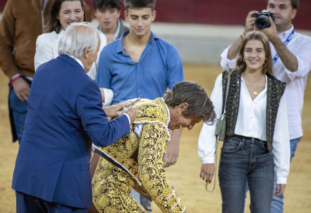 Manuel Benítez 'El Cordobés' corta la coleta a Manuel Díaz 'El Cordobés', en la despedida de su hijo de la plaza de toros de Jaén.
