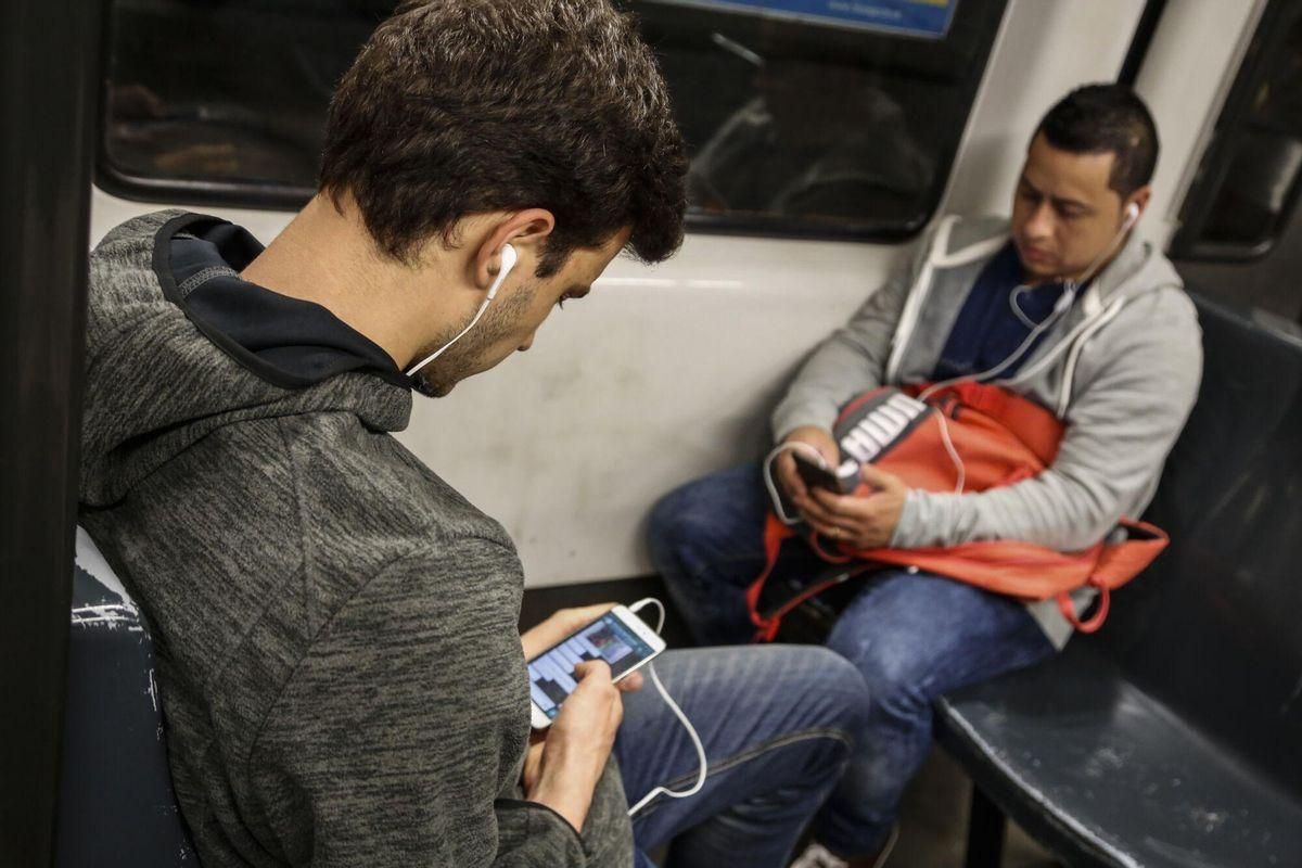 Dos hombres con los auriculares puestos en un viaje en metro. / JULIO CARBO Dos hombres con los auriculares puestos en un viaje en metro. / JULIO CARBO