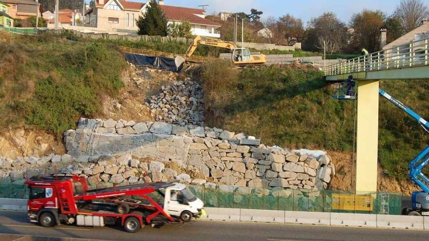 Una máquina trabaja en las obras de reparación del talud, ayer, junto a la autopista en Chapela. // FdV