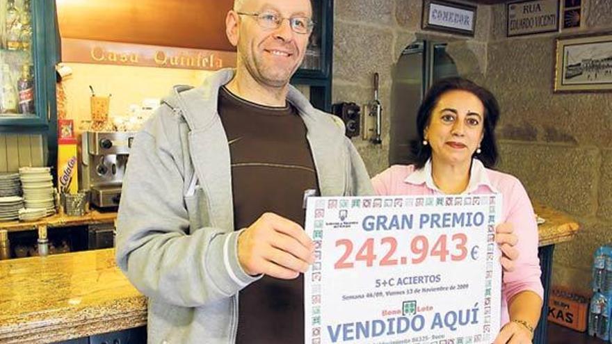 Antonio y Miluca Quintela junto al cartel que anuncia que el boleto premiado fue sellado en su local.  // Carmen Giménez