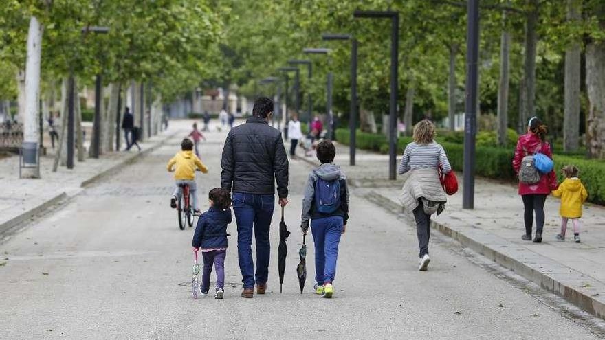 Familias con niños pasean por la calle, ayer, en Granada.