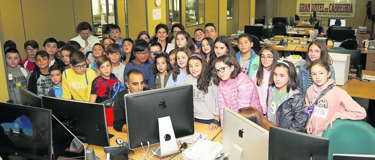 Niños y docentes de sexto de Figueiroa,con Elías Regueira de Maquetación, ayer, en la central de FARO DE VIGO en Chapela.  // Alba Villar