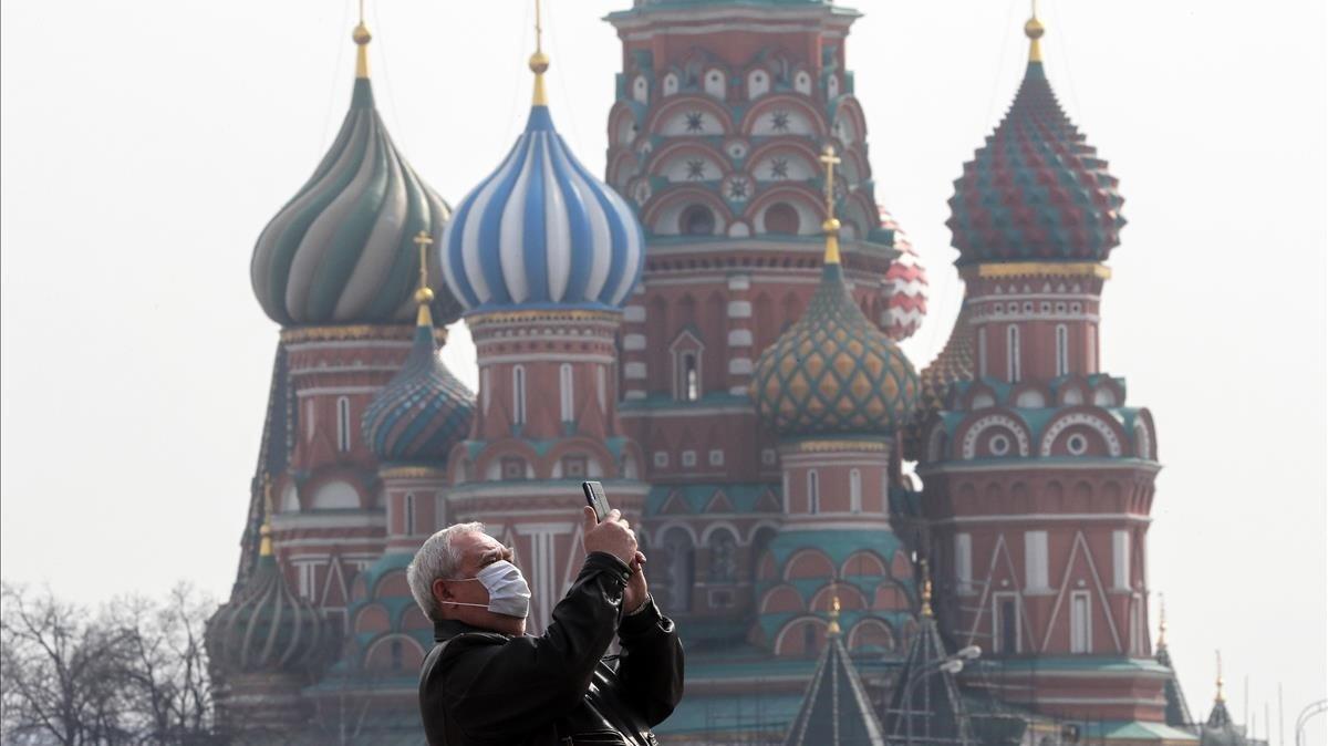 Un hombre hace fotos frente a la catedral de Vasily the Blessed en la Plaza Roja de Moscú
