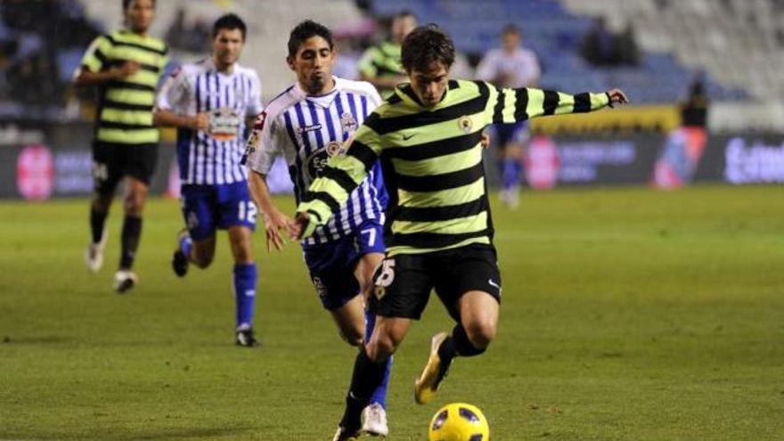 Urreta controla un balón ante Miguel Torres, durante el choque ante el Getafe en Riazor. / fran martínez