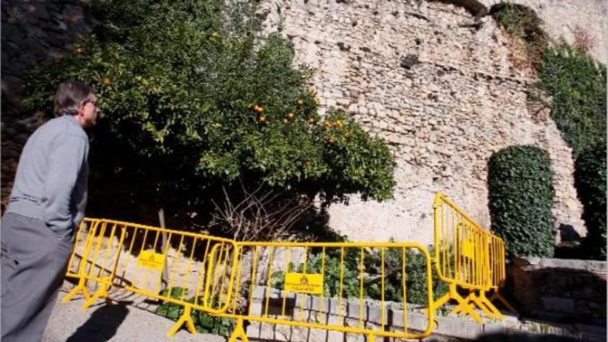 Un home, al Jardí de l&#039;Àngel, observa el tram de muralla afectat i que ja s&#039;ha protegit amb tanques.