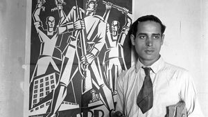 Helios Gómez junto a uno de sus carteles