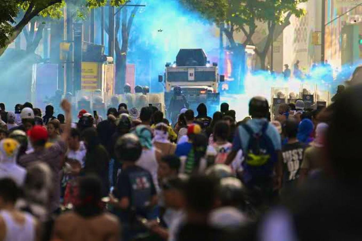 Las fuerzas de seguridad venezolanas, tanque incluido, frente a un grupo de manifestantes.