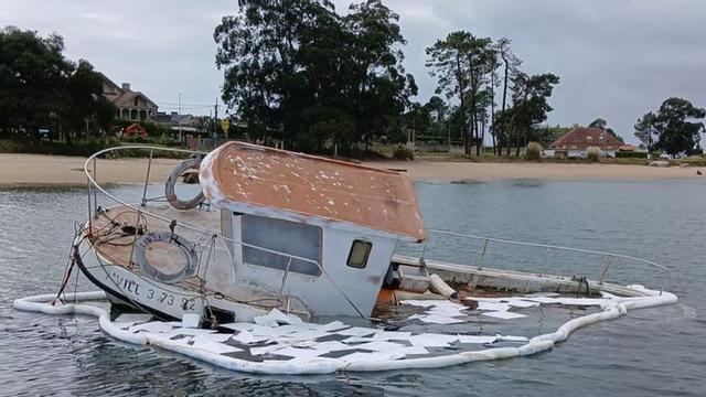 El barco fue rodeado con barreras anticontaminación.