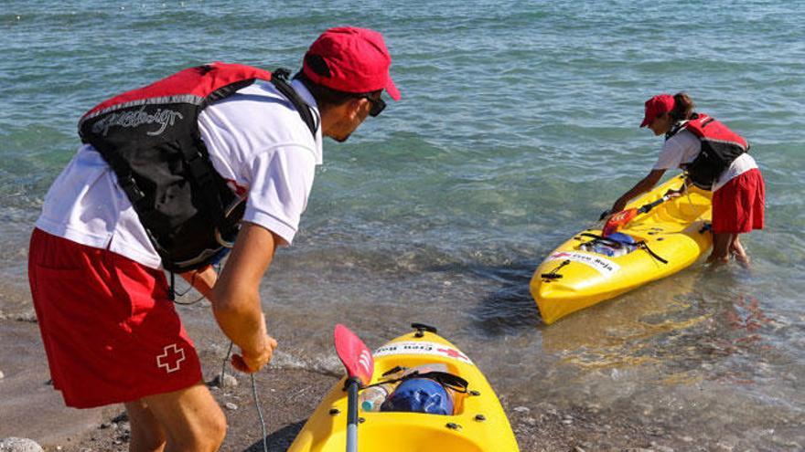 Arantxa Guasch y Silvio Graioni se preparan para subir a los kayaks con los que se acercan a las embarcaciones para informar sobre la posidonia y avisar a los que estén mal fondeados