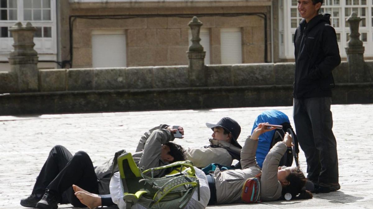 Un grupo de peregrinos asiáticos, en la praza do Obradoiro, tras completar el Camino de Santiago / JESÚS PRIETO