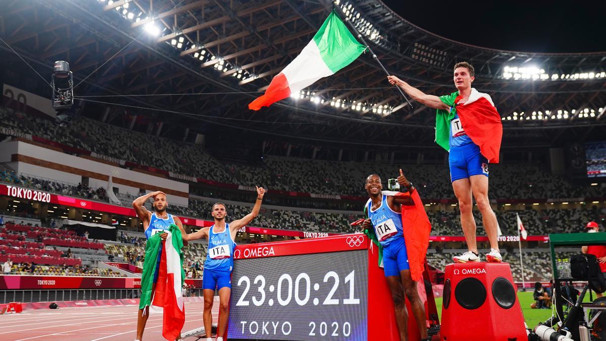 Los relevistas italianos, con la bandera de su país tras la carrera.